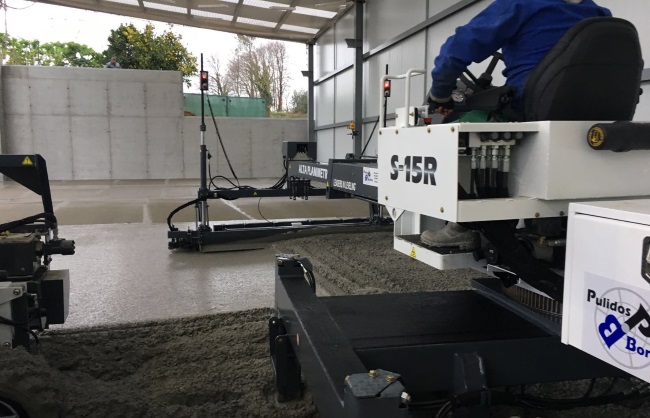 Extendedora láser S-15R hormigonando una solera industrial en nave